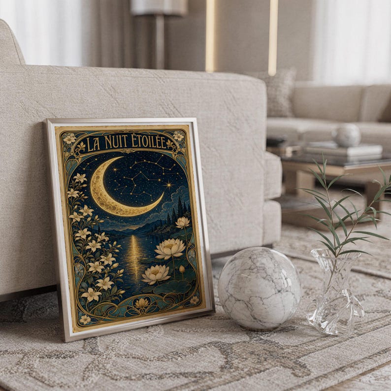 A framed vertical art print titled La Nuit Etoilee leaning against a sofa next to a marble sphere and a glass vase.