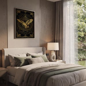 Celestial owl wall art print hanging above a bed with sage green pillows in a calm neutral bedroom.