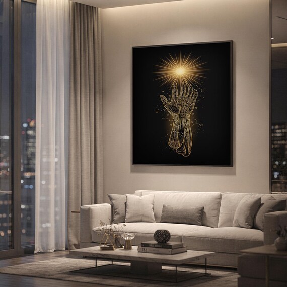 Celestial hand wall art print hanging above a light gray sofa in a modern living room with evening city views through tall windows.
