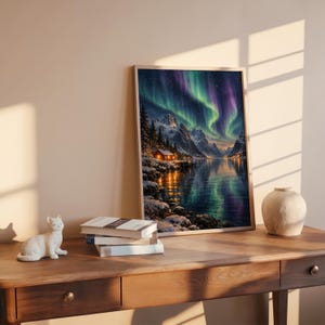 Aurora borealis mountain landscape wall art print leaning on a wooden desk against a warm beige wall in soft window sunlight.