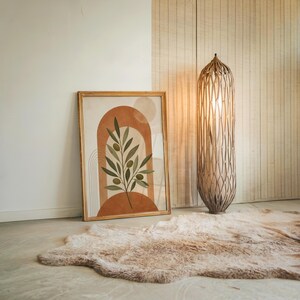 Mid century botanical print leaning on floor with large floor lamp