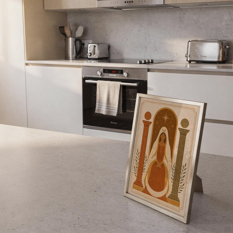 Framed boho terracotta arch poster resting on a light tile floor in a modern minimalist kitchen interior.