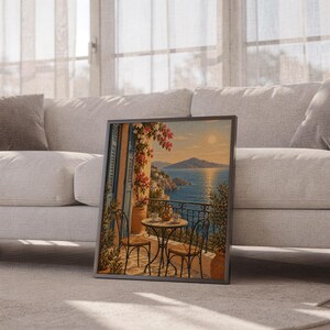 Mediterranean balcony wall art print leaning against a white sofa in a bright living room with sheer curtains.
