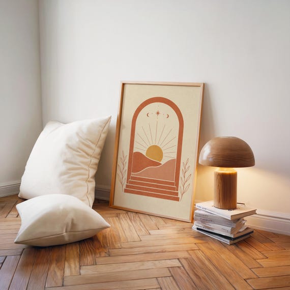 Minimalist sun landscape poster leaning on wooden floor next to vintage desk lamp