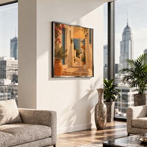Mediterranean coastal village wall art print hanging in a high-rise apartment living room with a city skyline view.