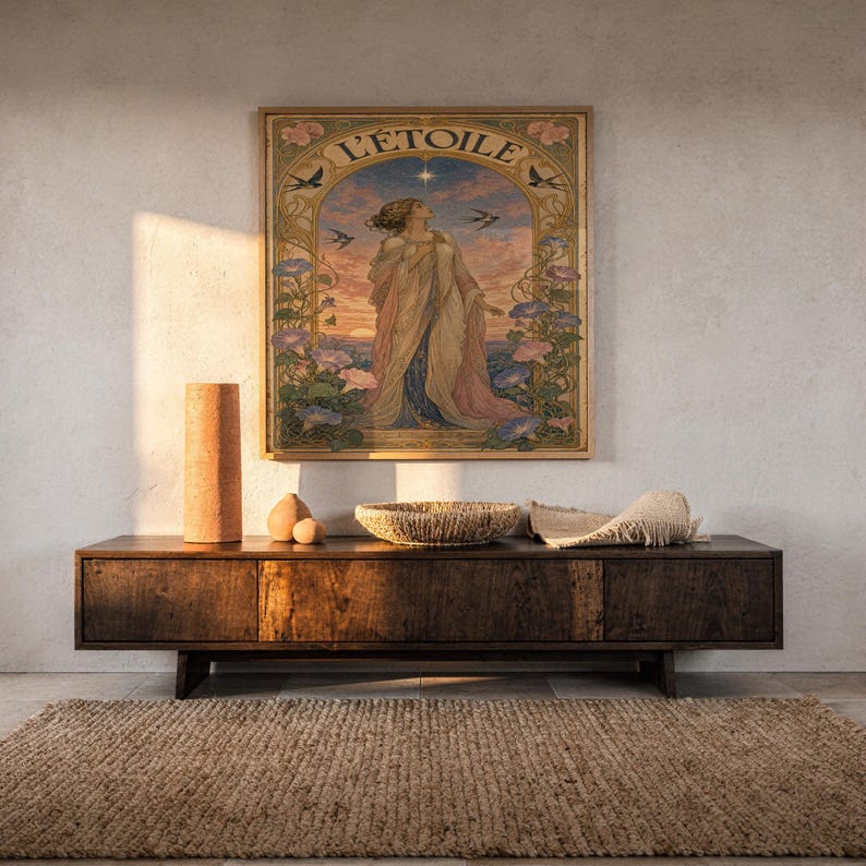 A framed L Etoile vintage-style poster mounted on a concrete wall above a dark wooden credenza with decorative objects.