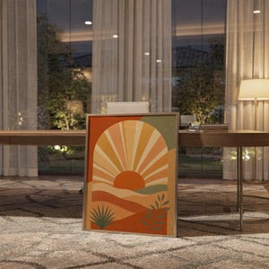 Boho sun arch print standing on a wooden desk in a home office in warm evening light.