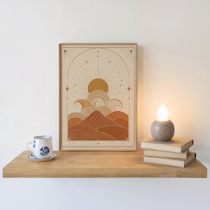 Single framed celestial print resting on a wooden floating shelf with cozy candle decor.