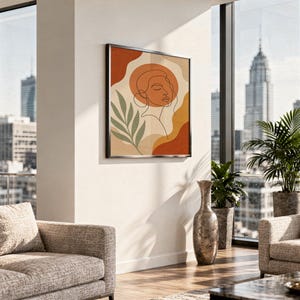 Abstract line art face print hanging above a stone countertop with a fruit bowl in a sunny kitchen.