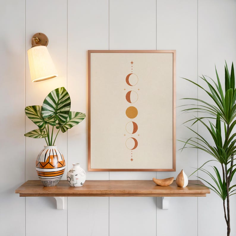 Celestial wall art poster on floating wooden shelf above green indoor houseplants