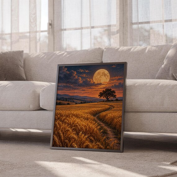 Moon wall art print leaning against a white sofa in a bright living room with sheer curtains.