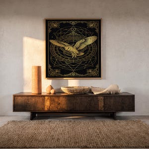 Celestial owl wall art print hanging above a dark wood console and jute rug in a warm neutral interior.
