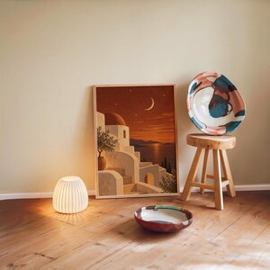 Print size guide for the mediterranean moonlit coastal wall art print: framed examples in 12x16, 16x20, 18x24, 23.4x33.1 and 24x36 inches on a warm beige wall above a cream sofa; 14 sizes available from 5x7 to 36x48 inches, prints ship unframed.