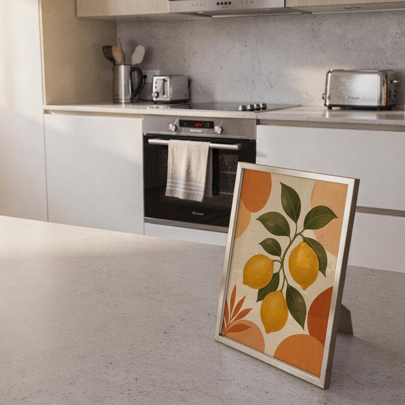 Lemon branch botanical print standing on a countertop in a modern white kitchen.