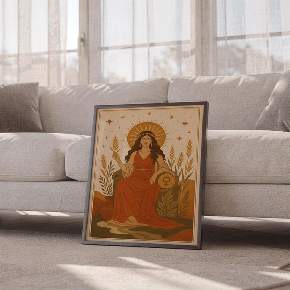 Celestial goddess wall art print leaning against a white sofa in a bright living room with sheer curtains.