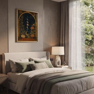 Moon phase wall art print hanging above a bed with sage green pillows in a calm neutral bedroom.