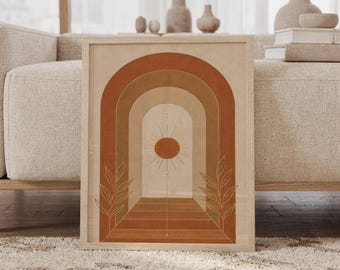 May include: A framed wall art print featuring a series of nested arches in shades of terracotta, tan, and cream. The center of the composition displays a sun icon with radiating lines, flanked by two thin, gold-toned line art botanical illustrations.