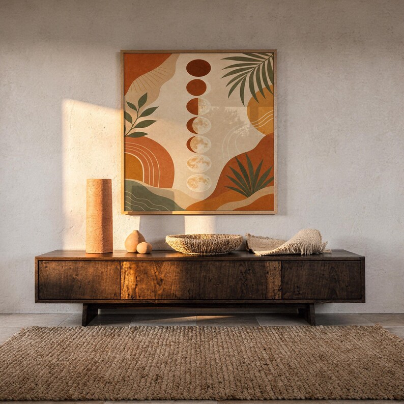 Boho moon phases art print hanging above a dark wood console and jute rug in a warm neutral interior.