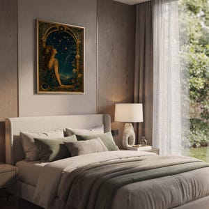Celestial woman wall art print hanging above a bed with sage green pillows in a calm neutral bedroom.