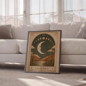 Boho celestial moon poster framed leaning against sofa in cozy sunlit living room setup.