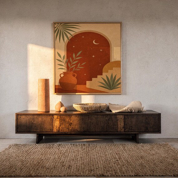Terracotta moon and stars arch art print hanging above a dark wood console and jute rug in a warm neutral interior.