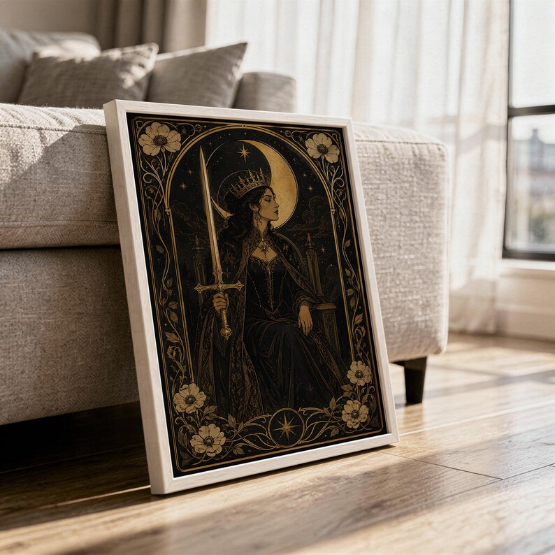 Gothic moon queen wall art print in a white frame leaning against a gray sofa on a sunlit wooden floor.