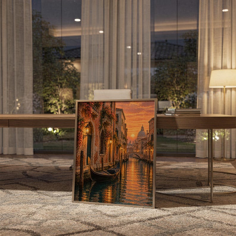 Venice canal sunset wall art print standing on a wooden desk in a home office in warm evening light.
