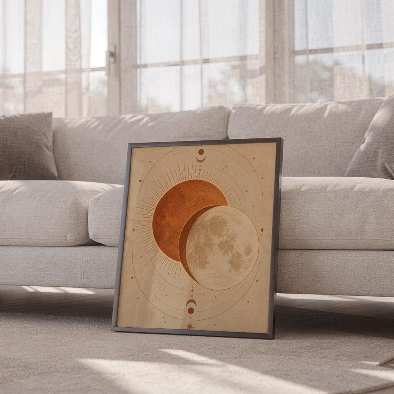 Sun and moon celestial wall art print leaning against a white sofa in a bright living room with sheer curtains.