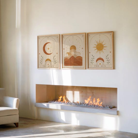 Set of 3 framed celestial poster set hanging above a modern fireplace in a bright room.