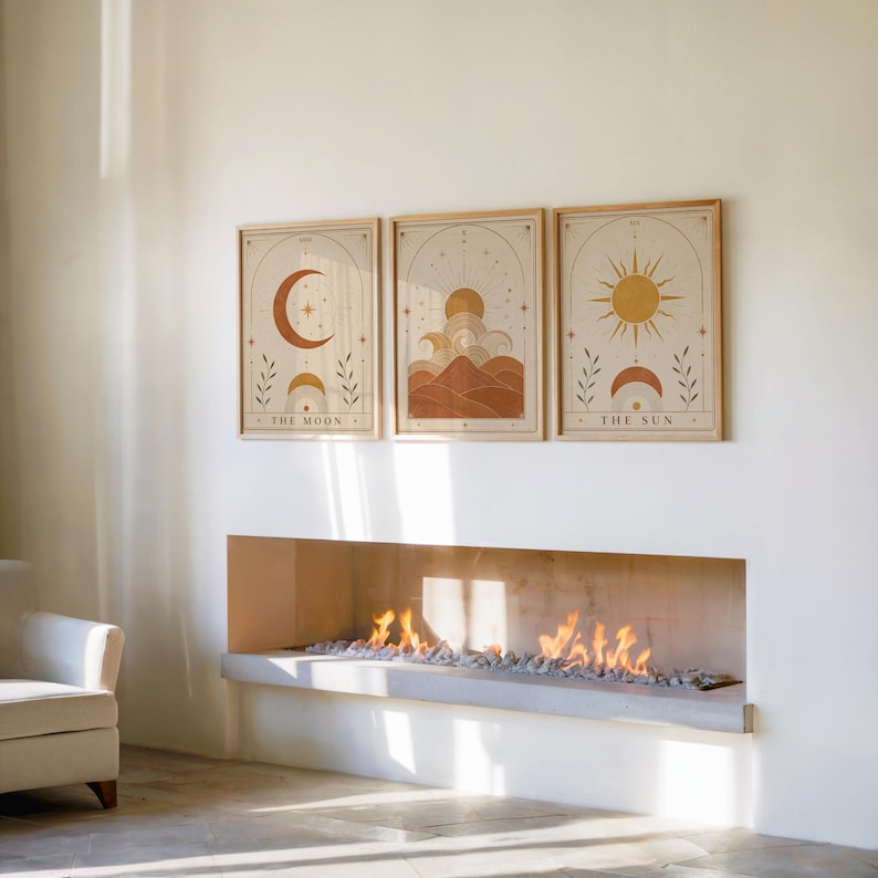 Set of 3 framed celestial poster set hanging above a modern fireplace in a bright room.