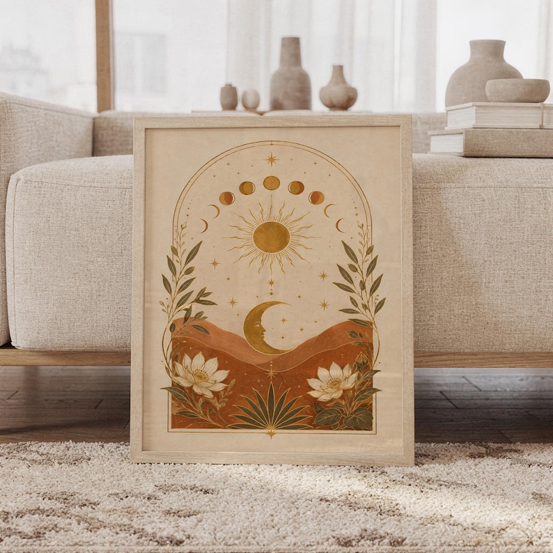Celestial sun and moon wall art print featuring warm gold, terracotta, cream, and olive tones, moon phases, a radiant sun, crescent moon, stars, mountains, and botanical flowers in a vintage boho style, framed and leaning against a beige sofa on a textured rug in a bright Scandinavian living room.