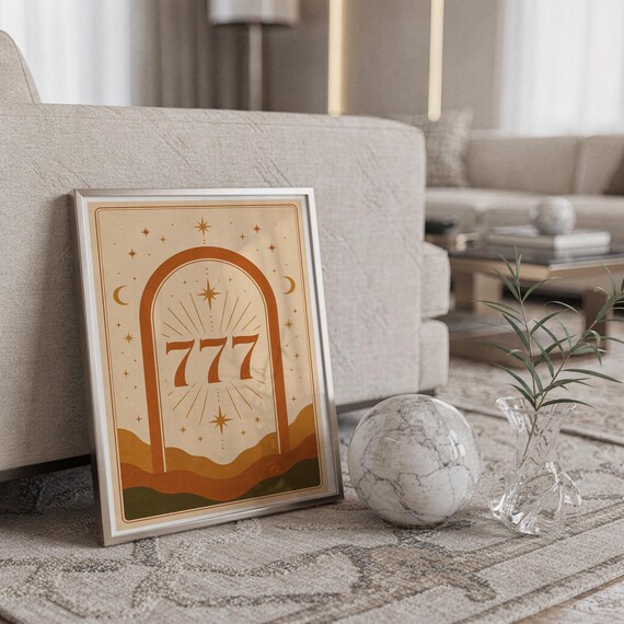 Minimalist framed 777 lucky number print leaning against a light beige sofa next to a decorative marble sphere on a rug.