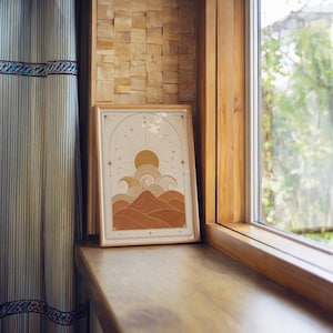 Neutral celestial ocean print framed on wooden window sill with soft natural light.