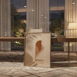 Framed abstract wall art leaning on a shelf in a study room with warm ambient night light.