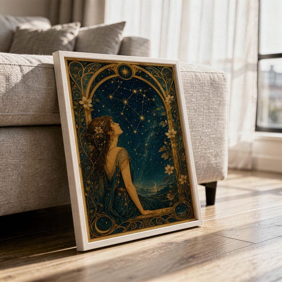 Celestial woman wall art print in a white frame leaning against a gray sofa on a sunlit wooden floor.