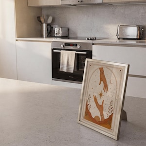 Vintage style hands tarot poster framed on kitchen island counter in modern bright home.