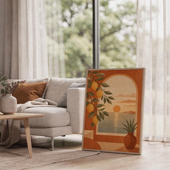 Mediterranean lemon and sea view arch print leaning on the floor beside a cream armchair next to large garden windows.