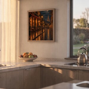 Paris eiffel tower wall art print hanging above a stone countertop with a fruit bowl in a sunny kitchen.