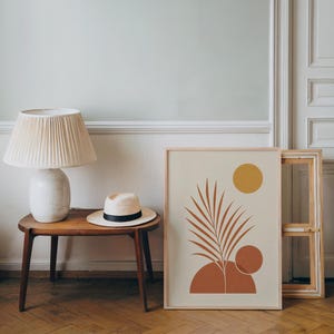 Minimalist palm leaf poster resting on wooden side table in bright living room setup