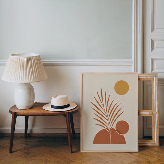 Minimalist palm leaf poster resting on wooden side table in bright living room setup