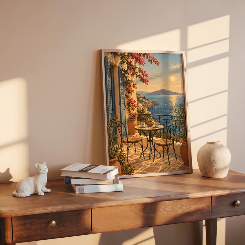 Mediterranean balcony wall art print leaning on a wooden desk against a warm beige wall in soft window sunlight.
