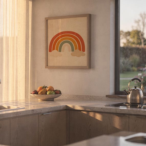 Boho earth tone rainbow print hanging above a stone countertop with a fruit bowl in a sunny kitchen.