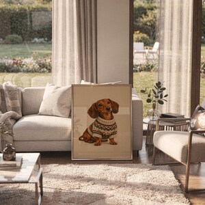 Dachshund sweater wall art print in a silver frame leaning against a sofa beside a decorative marble sphere.