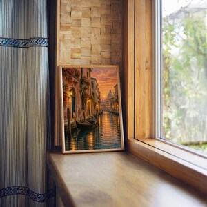Venice canal sunset wall art print standing on a wooden window sill in warm natural light.