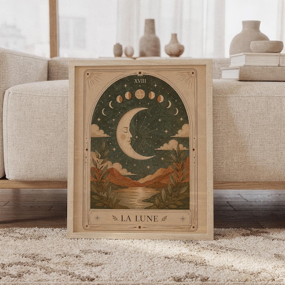 Framed La Lune moon tarot card art print leaning on carpet in front of sofa in bright living room.