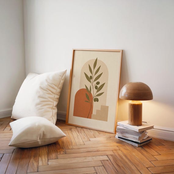 Modern olive leaf wall art poster on wooden floor with ambient lamp