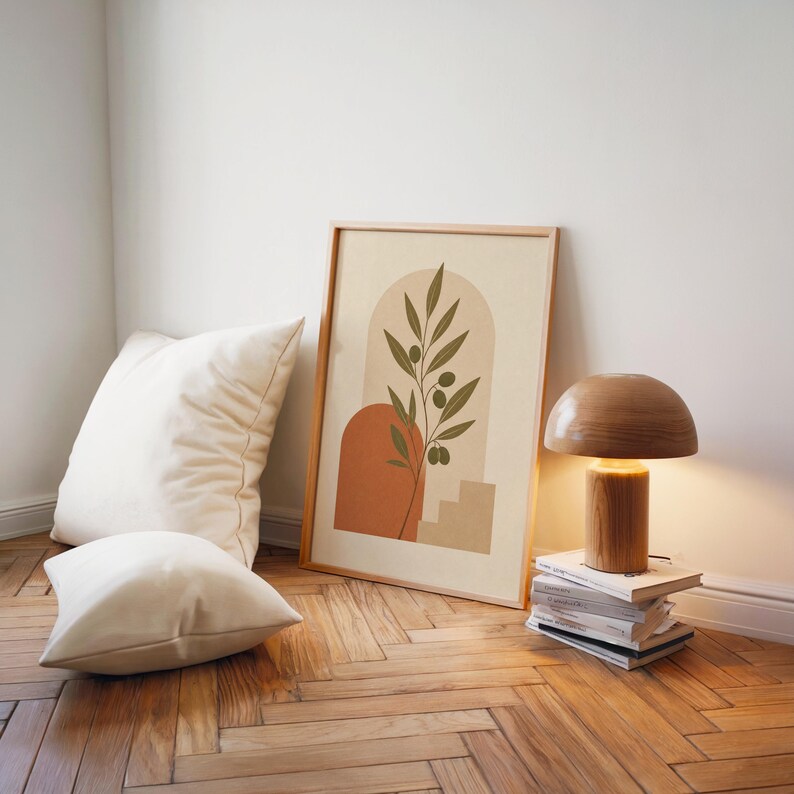 Modern olive leaf wall art poster on wooden floor with ambient lamp