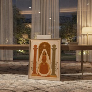 Terracotta vase and arch print in a sleek frame resting on the floor in a cozy evening dining space.