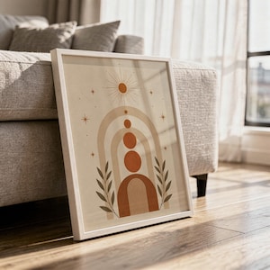 Large framed boho geometric arch poster on hardwood floor leaning next to sofa in sunlit room.