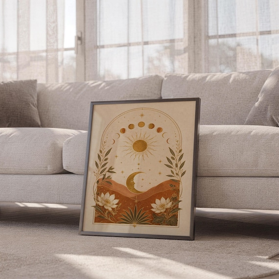 Celestial sun and moon wall art print leaning against a white sofa in a bright living room with sheer curtains.